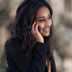 Outdoor of a portrait happy young black  teenage girl using a mobile phone